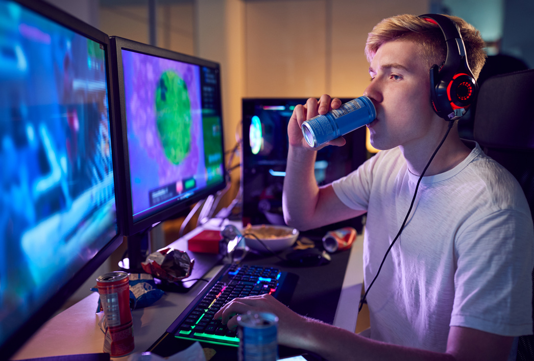 Teenage Boy Drinking Caffeine Energy Drink Gaming at Home Using